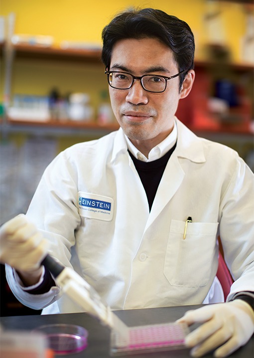 Man in white lab coat using a pipette.