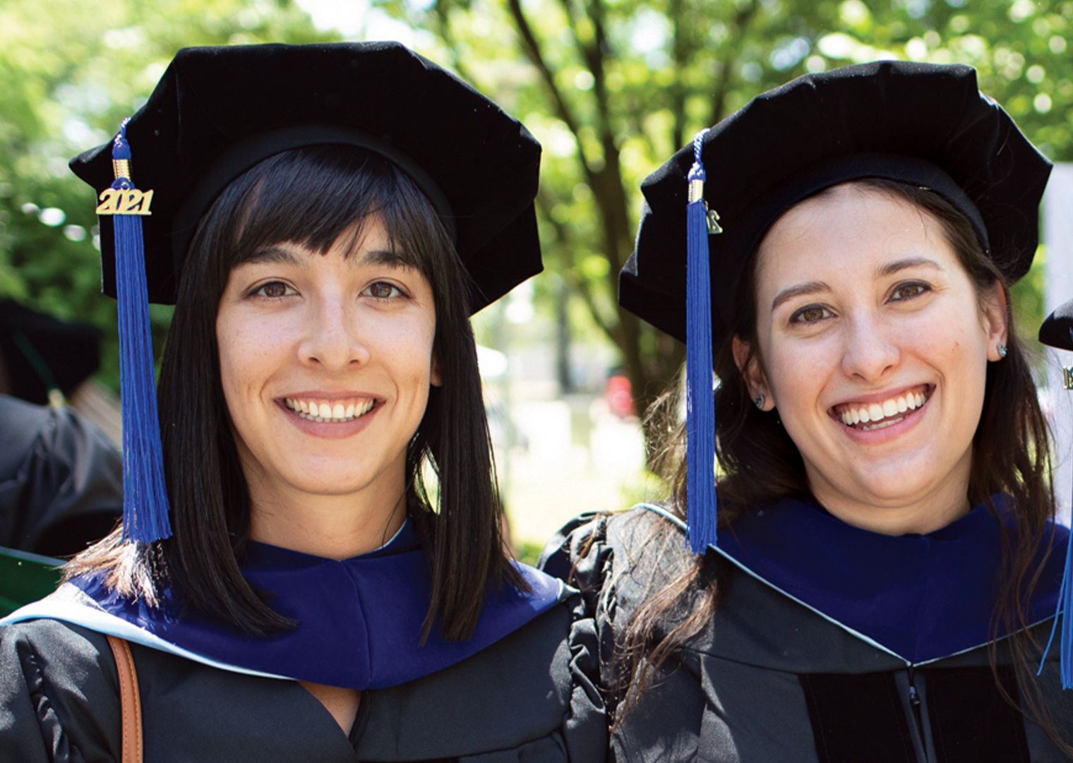 Two women in graduation caps with blue tassels.