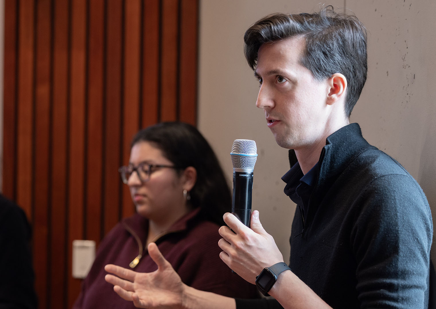Speaker holding a microphone during a panel discussion